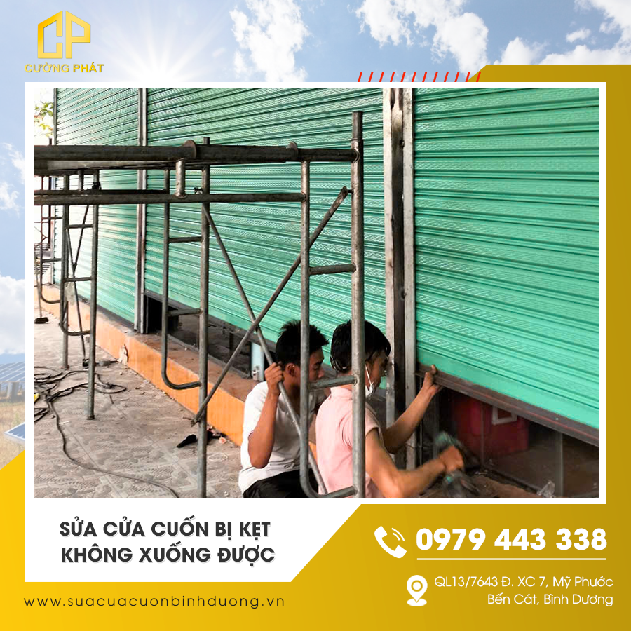 Thợ đang xử lý cửa cuốn bị kẹt không xuống được
